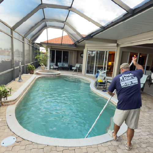 Pool technician vacuuming a residential pool in Charlotte County