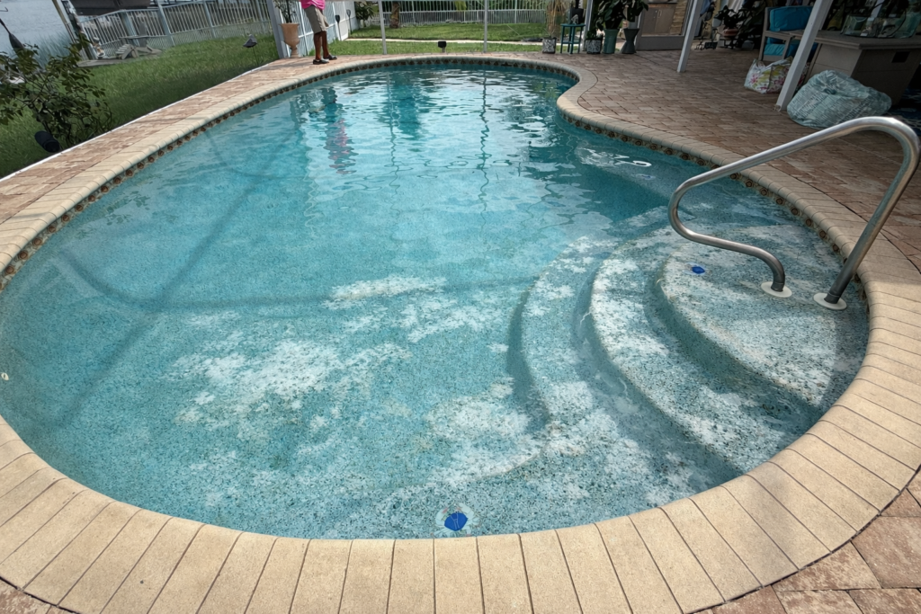 Mineral pool stains caused by calcium and mineral buildup on a pool surface in Florida