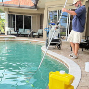 Brushing and cleaning a residential pool during a 21-point inspection and weekly service