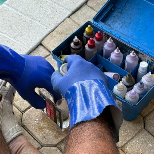 Technician testing pool water chemistry levels using professional test kit in Punta Gorda, Florida
